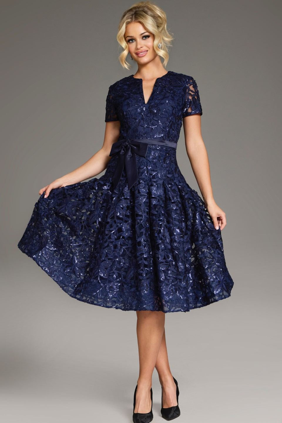 "Elevate your evening look with the Jovani 39427 homecoming dress. Featuring a charming V-neck, delicate lace overlay, short sleeves, and a trendy belt, this knee-length A-line dress is perfect for any event. Shop party perfection at FOSTANI!"